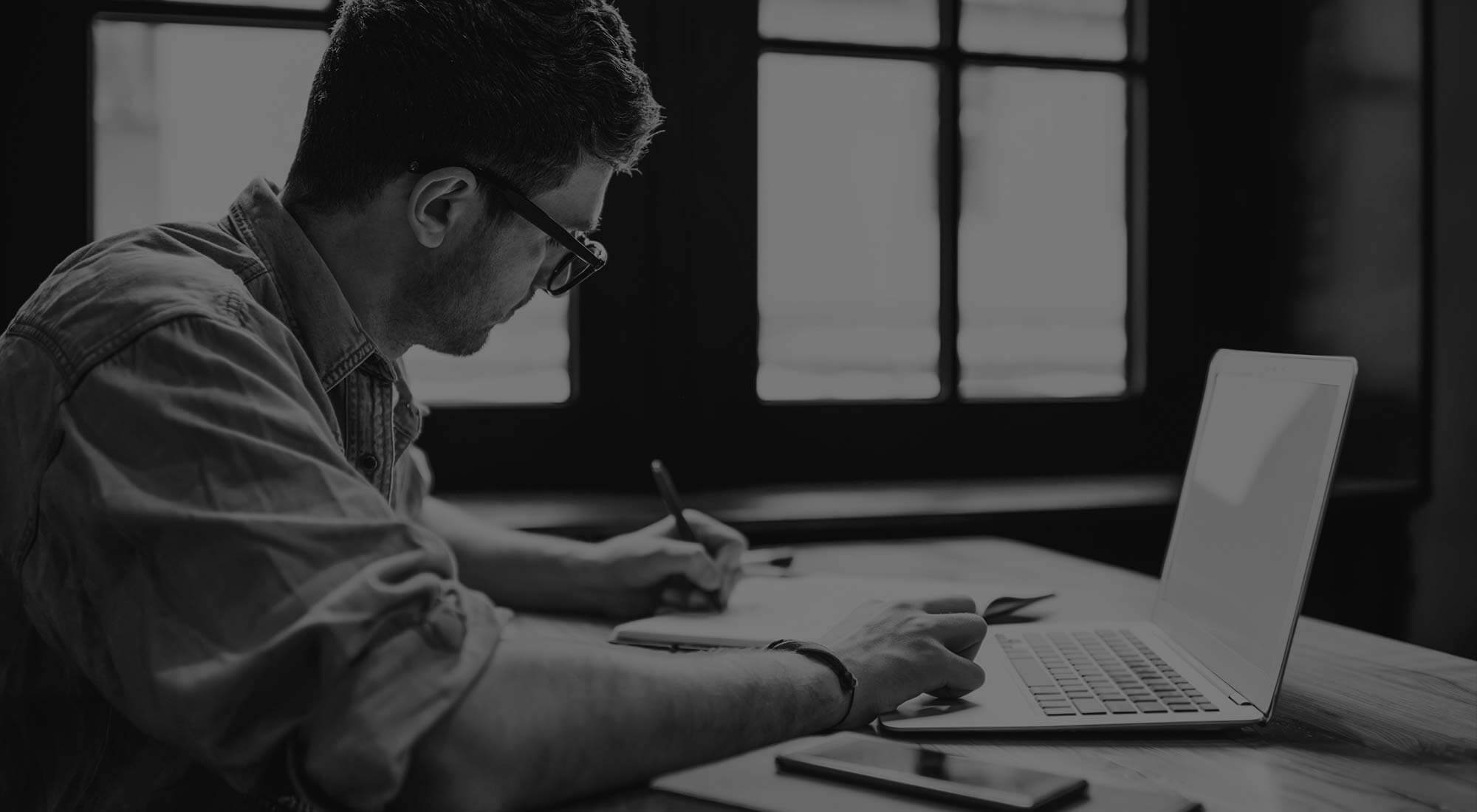 man writing on laptop