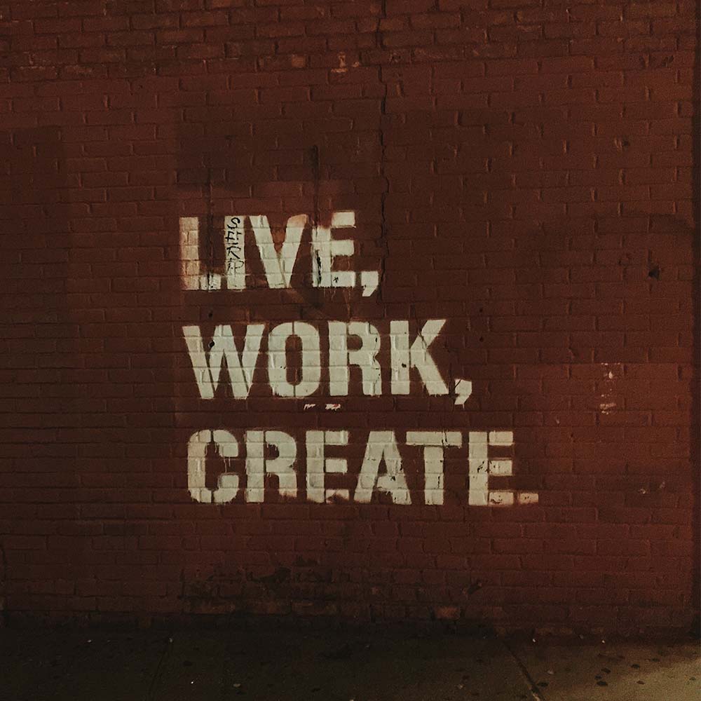 a brick wall with the words; live, work, create on it