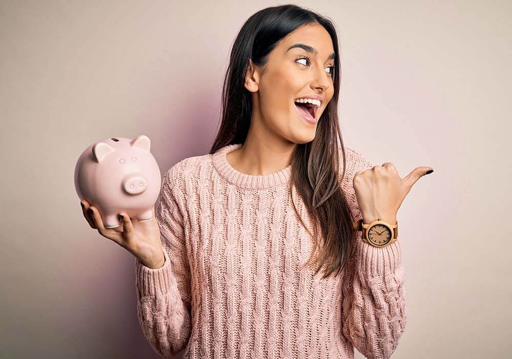 woman in pink holding a piggy bank
