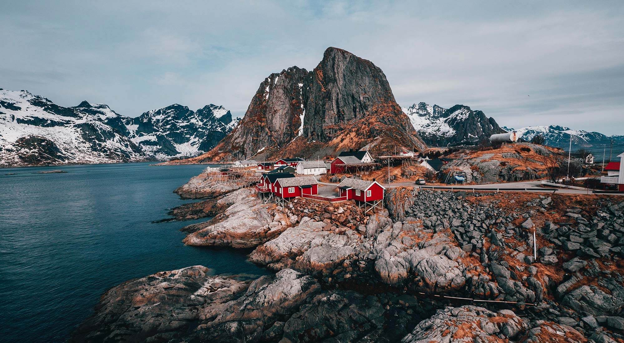 norwegian house with snowy mountains by the sea